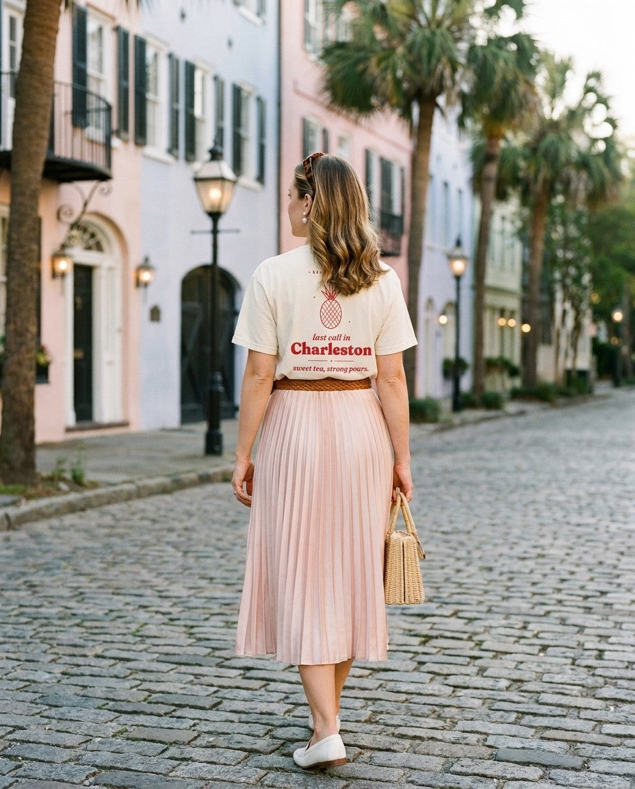 Charleston Bachelorette Oversized Tee in Ivory with a pleated satin skirt on a cobblestone street