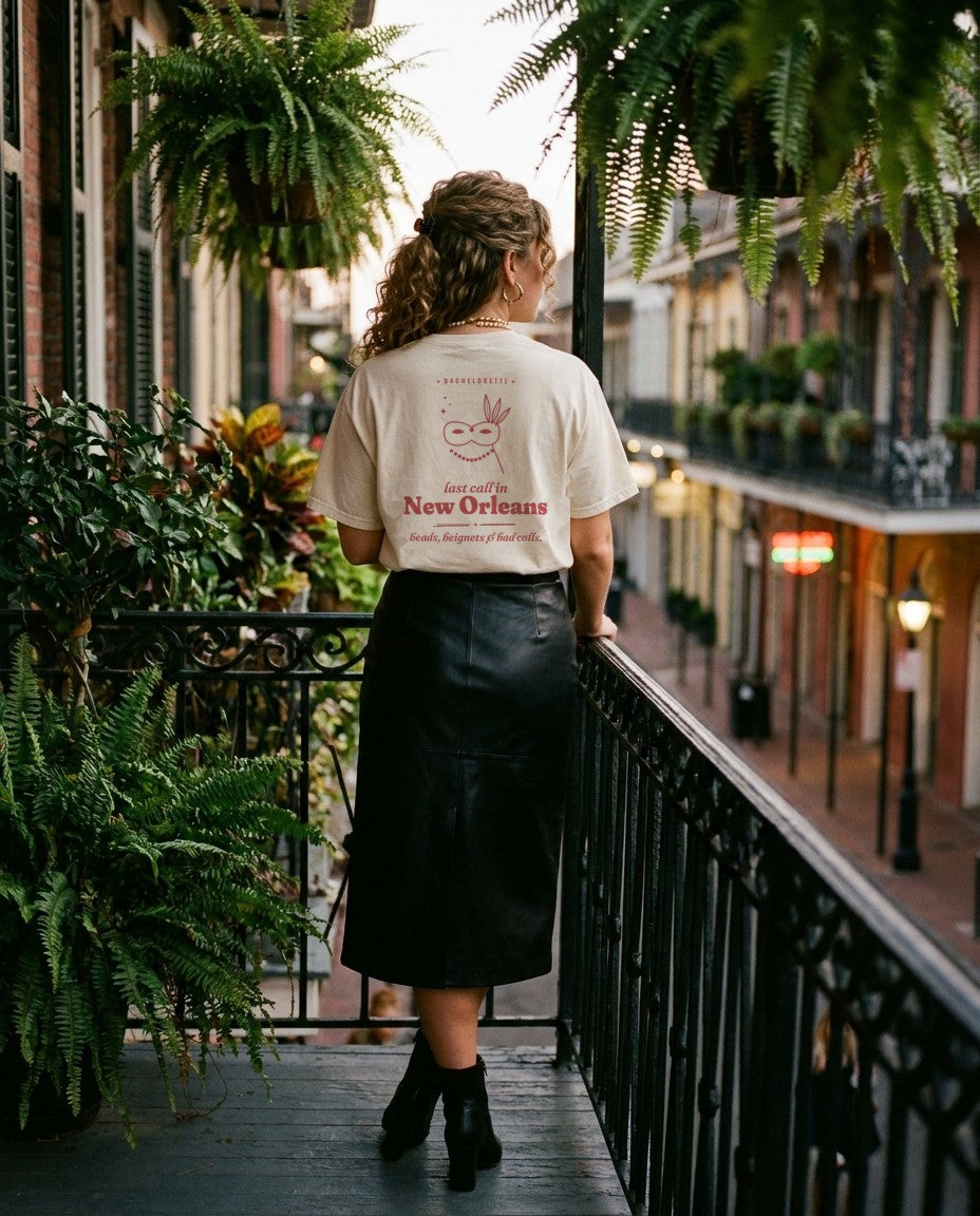 New Orleans Bachelorette Oversized Tee in Ivory with a leather midi skirt on a French Quarter balcony