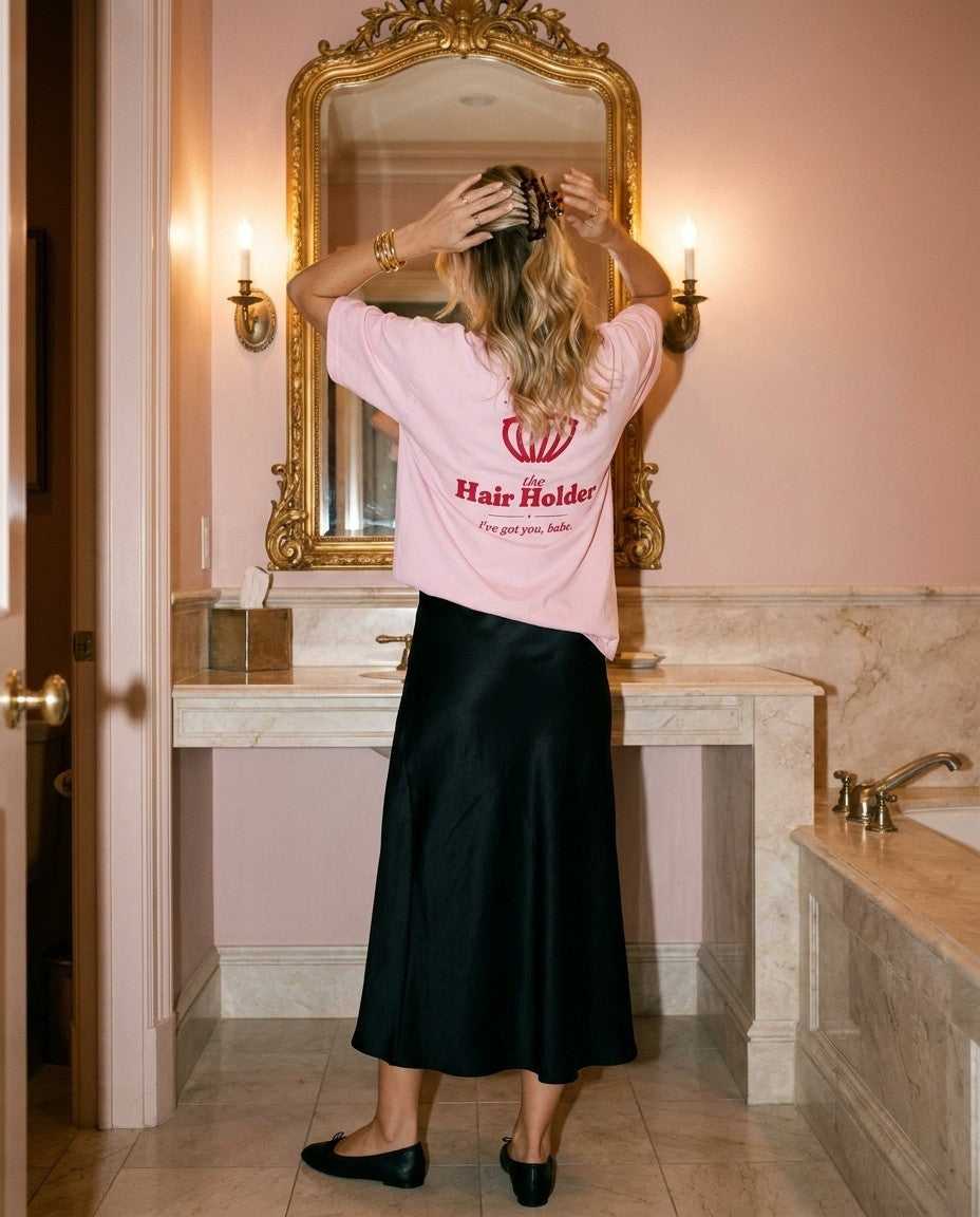 The Hair Holder Oversized Tee in Blossom with a black satin skirt in a powder room